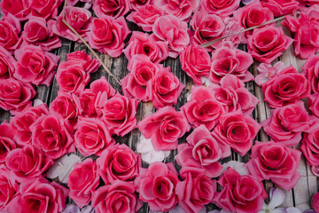 artificial pink roses made from fabric decorated on wooden board background, romance flower backdrop wallpaper 