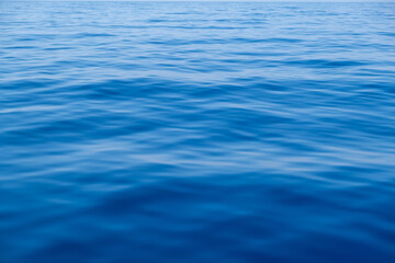 Naklejka premium Sea water surface calm with small ripples. Still ocean, deep blue color background,.