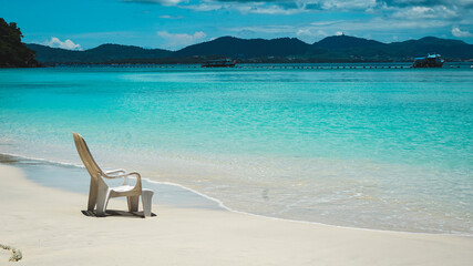 Fototapeta na wymiar Lonely beach chair with cloudy blue sky and sun at coral island, phuket, thailand