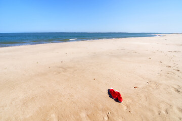 Fototapeta na wymiar Red shoes left on a sandy beach . Loire-Atlantique coast