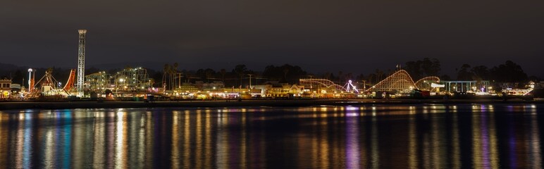 Panoramic views of Santa Cruz Beach Boardwalk Amusement Park with night reflections. Santa Cruz, California, USA.