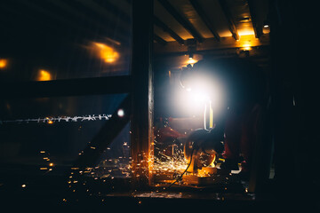 A man is sawing metal pipes on a plunge-cut miter saw. Sparks is flying from under the disc. The working process. DIY construction. Hobby. Safety precautions for using power tools. Protection means