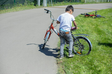 Fototapeta na wymiar A child on a bicycle. A child in the park rides a bicycle.