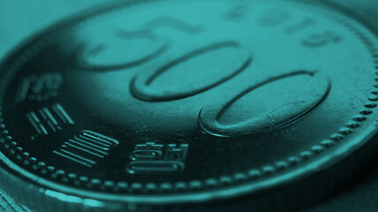 Translation: Bank of Korea. 500 won coin close-up. Dark blue green tinted background or wallpaper on an economic, financial or banking theme. Money and business in South Korea. Korean won. Macro