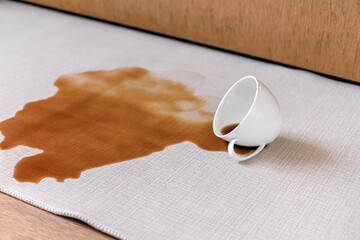 Spilled coffee on a white carpet. The concept of cleaning stains