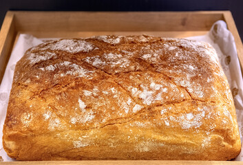 Big ciabatta on wooden pallet in bakery.