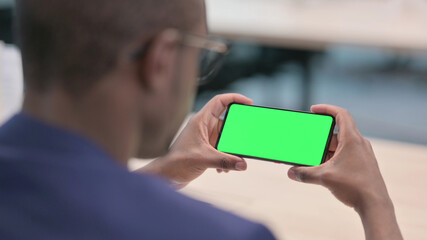Young African Businessman Looking at Smartphone with Chroma Screen