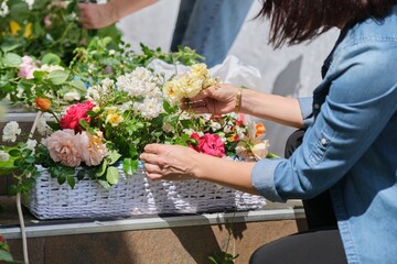 Obraz na płótnie Canvas Female florist working with flowers outdoors, decorating events with flowers