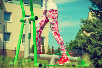 Girl doing legs exercises in outdoor gym