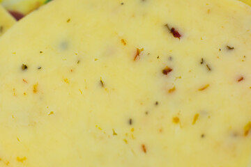 Yellow cheese with herbs and spices background Texture . Close up, macro photo.