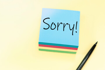 Text SORRY handwritten with black pen on a blue stiker.