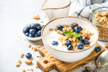 Greek Yogurt with granola and blueberries at stone table. Healthy food, snack or breakfast.