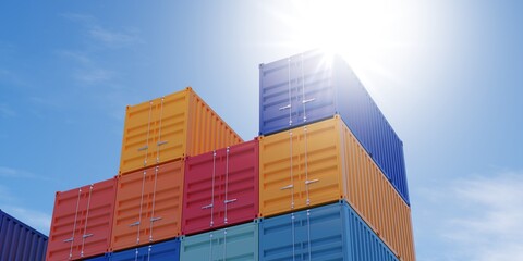 Fototapeta premium Stacked industrial intermodal cargo transport or shipping containers storage outside with blue sky and sun