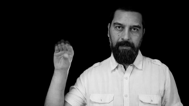 Annoyed bearded man showing bla bla bla gesture and grimacing over black studio background. Lier. Blah concept.