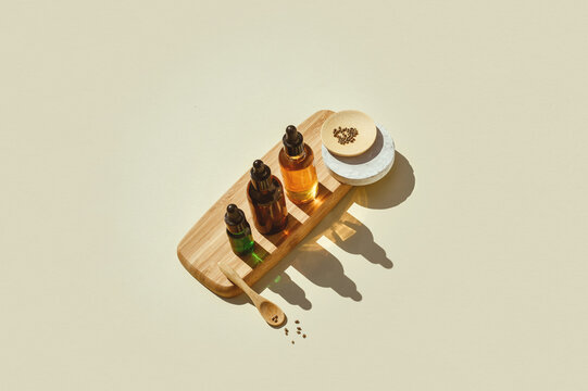 Various glass bottles with CBD oil, THC tincture capsule on beige background. minimalism