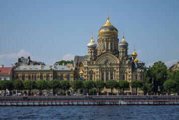 Fototapeta na wymiar beautiful Church of the Assumption of the Blessed Virgin Mary on the Lieutenant Schmidt embankment near the Neva River on a sunny clear summer day and a copy space in Saint-Petersburg
