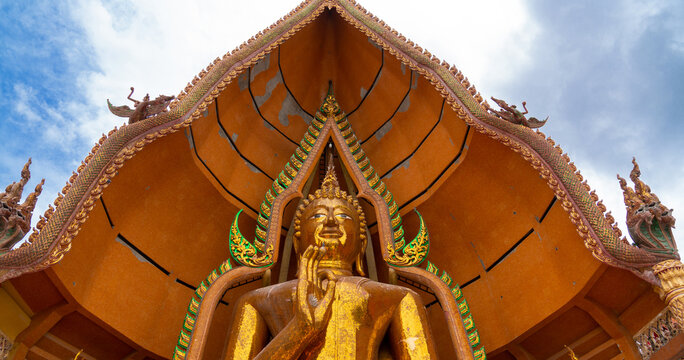 wide-angle closeup of golden big blessing buddha statue at Wat Tham Sua temple, Kanchanaburi Thailand.