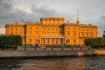 Fototapeta na wymiar beautiful facade of the orange Mikhailovsky Castle on the bank of the Fontanka River on a summer evening at sunset in Saint-Petersburg Russia