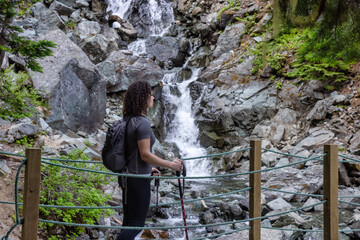 Adventurous White Caucasin Adult Woman Hiking on a trail in Canadian Nature. Garibaldi Lake Hike...