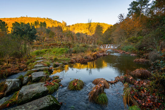 Mestres weir on the Piscaredo hiking path and autumn fall landscape with Cabril River at sunset in Mondim de Basto, Norte, Portugal