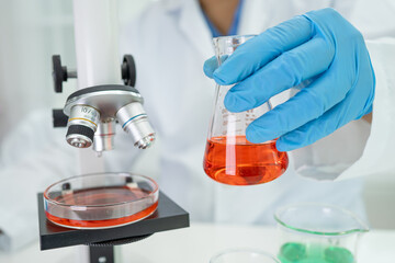 Fototapeta premium Asian scientist biochemist or microbiologist working research with a microscope in laboratory. 