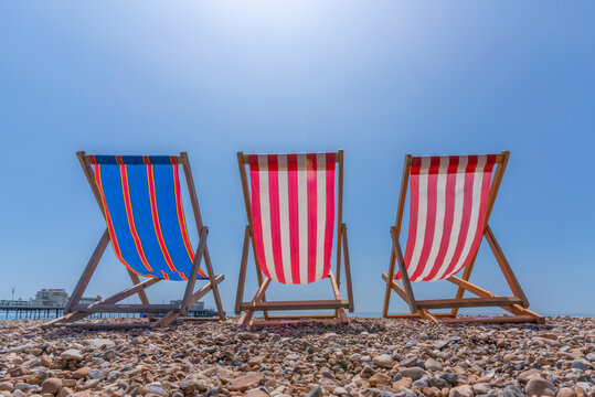 View of Worthing Pier and colourful deckchairs on Worthing Beach, Worthing, West Sussex, England
