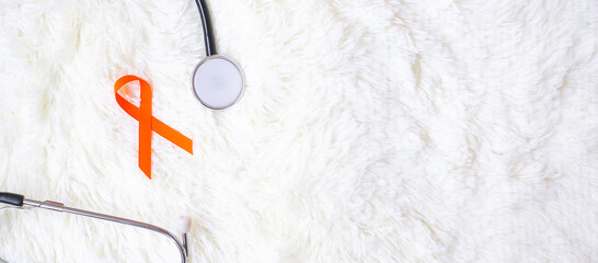 Leukemia, Kidney cancer day, world Multiple Sclerosis, CRPS, Self Injury Awareness month, Orange Ribbon with stethoscope for support people living and illness. Healthcare and World cancer day concept