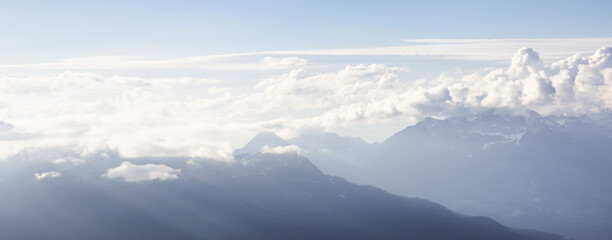 Aerial View from Airplane of Canadian Mountain Landscape. Sunny Summer Clouds before sunset. Taken between Squamish and Whistler, North of Vancouver, BC, Canada.