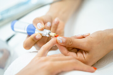 Woman in a nail salon receiving a manicure by a beautician with.