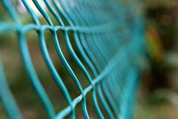 Steel grating fence of soccer field,Metal fence wire with grass in the background.
