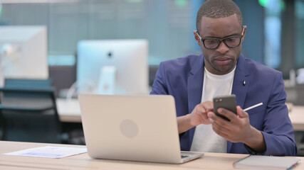 Young African Businessman using Smartphone in Office