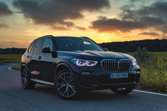 BMW X5 45e hybrid front end shot of the entire car at the sunset