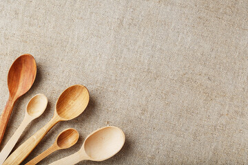 Fototapeta na wymiar Wooden spoons made of natural wood on burlap fabric as a craft.