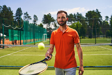 Male beginner tennis player mastering the serve technique