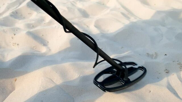 Head of Metal Detector Moving Over Sand on Seaside Beach in Resort to Find and Collect Items Lost by Tourists