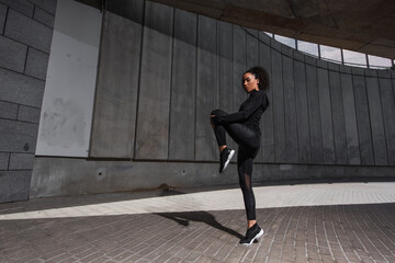 African american sportswoman exercising on urban street