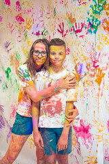 Fototapeta premium Portrait of a cute happy woman with her son painting and having fun