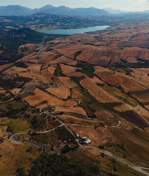 Aerial view of bare agricultural fields and winding roa