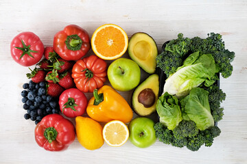Bunch of mixed fruits, berries, vegetables, herbs and green on white countertop. Vegan diet products. Clean eating concept. Close up, copy space, background, top view.