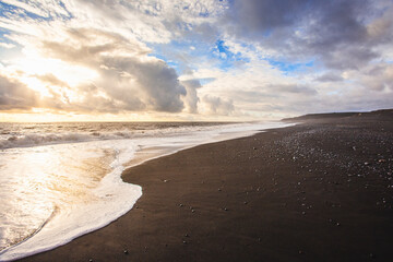 Black lava beach in the south of Iceland at sunset