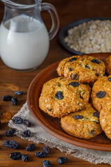 Fresh baked homemade oatmeal cookies with raisins and sunflower seeds on wooden background