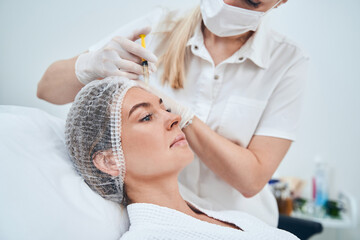 Serious female patient being on course of mesotherapy