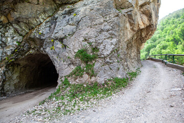 A tunnel made in the mountain and an old road around the mountain. Digorskoe gorge. North Ossetia. Russia.