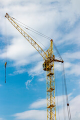 The work of tower cranes against the background of the sunset sky. Modern housing construction. Industrial engineering. Construction of mortgage housing.