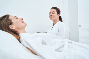 Positive delighted female person lying on couch