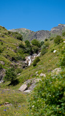 Fototapeta na wymiar Cascada en el valle de Otal con hermosas colinas verdes en España
