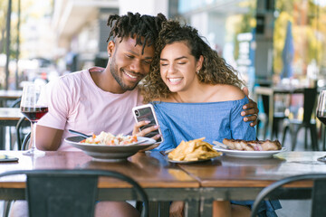 Couple using a mobile phone at a restaurant.