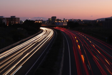 Vía cintura al atardecer con coches circulado deprisa.