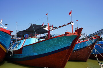 Fototapeta na wymiar A wooden fishing boat is parked at the mouth of the Juwana River, Pati, Central Java, Indonesia.