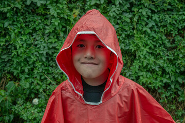 Niño con impermeable durante la lluvia veraniega.